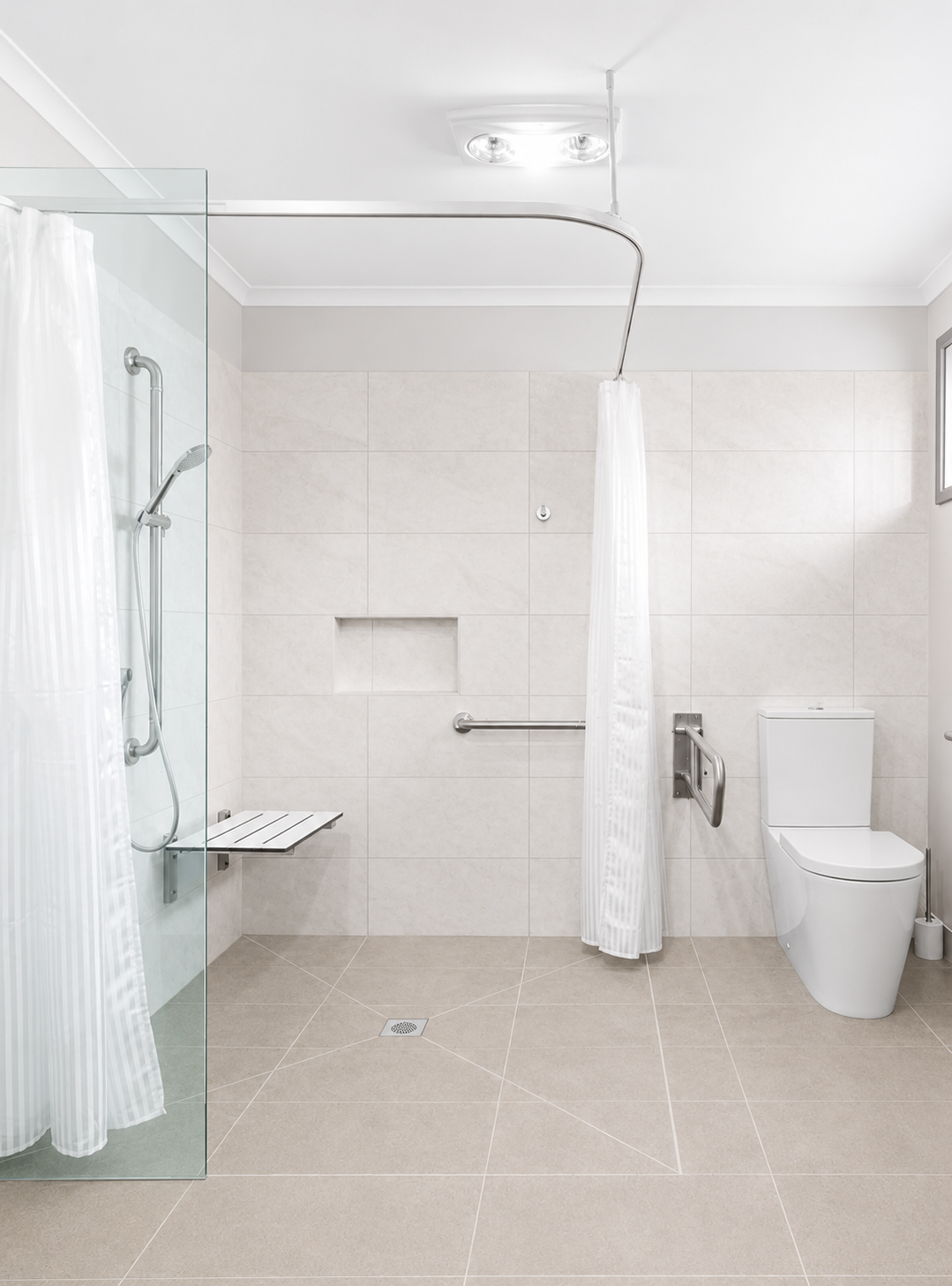 Accessible bathroom in a completed home — level-access shower with a fold-down seat, grab rails and a step-free tiled floor.